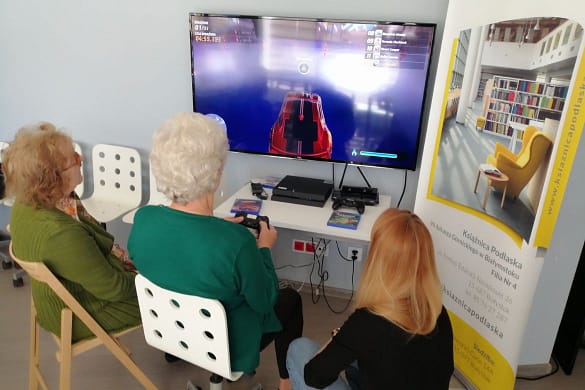 seniorki grają na konsoli w bibliotece